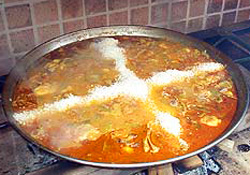 Los expertos no miden el arroz y calculan la medida haciendo dos montones con forma de cruz que sobresalgan de la paella un dedo, como se ve en la foto