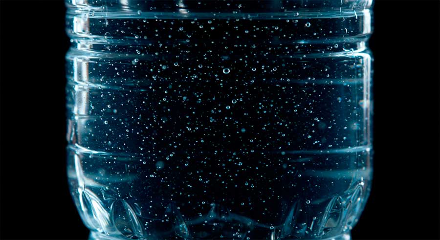 Botella de plástico con microplásticos en el agua