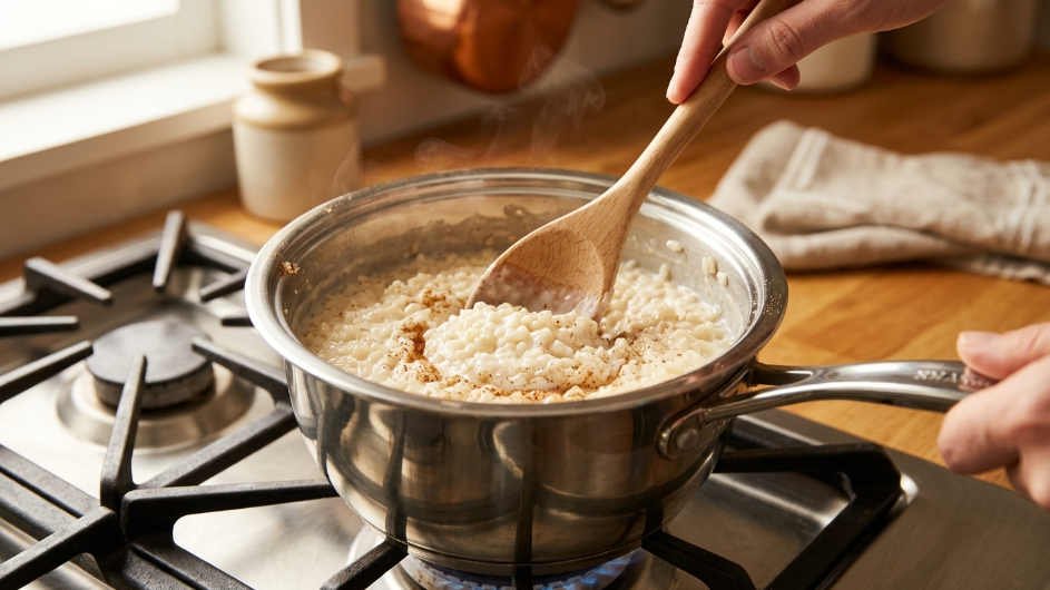 Arroz con leche cocinándose a fuego lento en olla de acero inoxidable