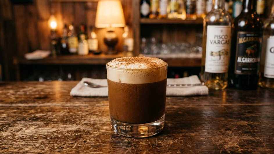 Cóctel de algarrobina peruano servido con espuma y canela