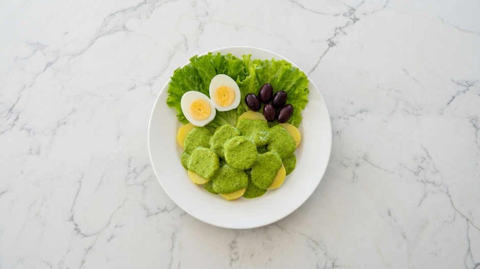 Receta de ocopa peruana con salsa verde de huacatay y maní sobre papas amarillas sancochadas